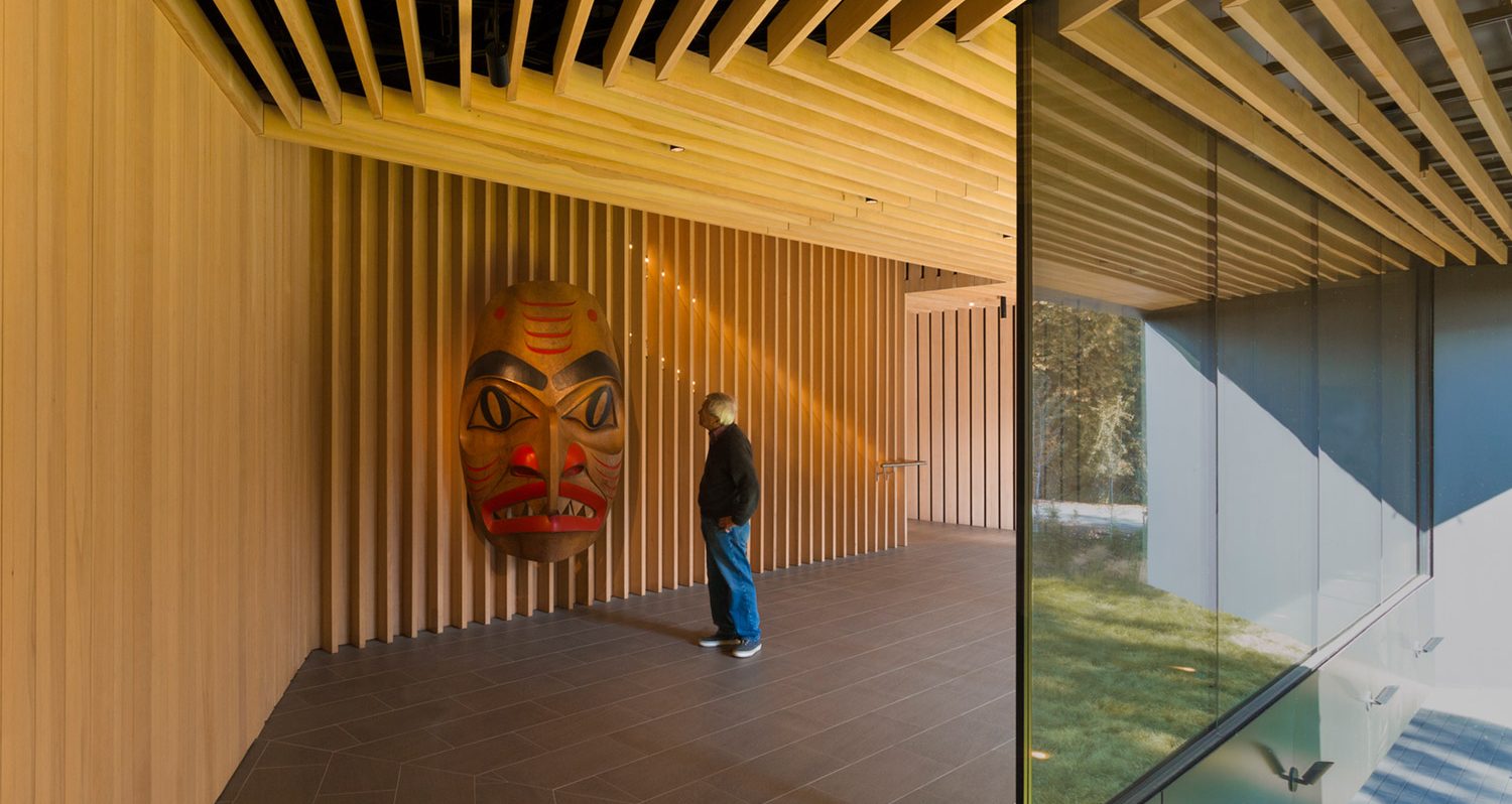 Audain Art Museum interior indigenous exhibit with man looking at a large mask